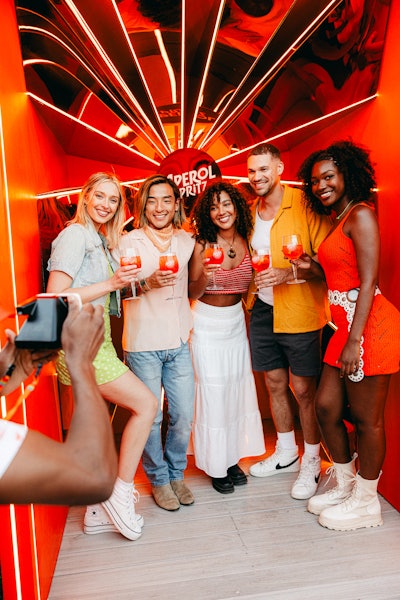 The bright orange Aperol Piazza stood out on festival grounds, drawing guests in with unique photo moments, digital activities, an interior tram, and a pergola rooftop that blew bubbles during golden hour each day.